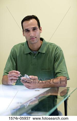 Portrait of a businessman sitting in an office holding a palmtop View Large Photo Image Stock Photo - Portrait of a businessman sitting in an office holding a palmtop. Fotosearch