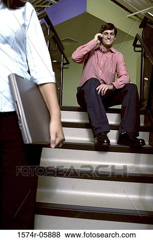 Portrait of a businessman sitting on stairs talking on a mobile phone View Large Photo Image Stock Photo - Portrait of a businessman sitting on stairs talking on a mobile phone. Fotosearch