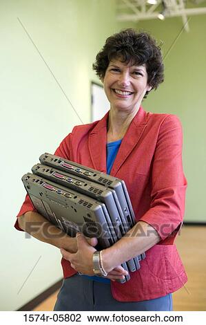 Portrait of a businesswoman carrying three laptops View Large Photo Image Stock Image - Portrait of a businesswoman carrying three laptops. Fotosearch