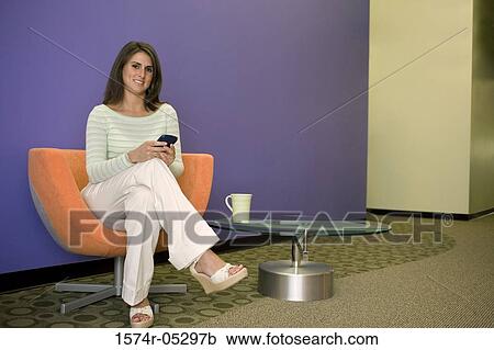 Portrait of a businesswoman sitting in an office holding a palmtop View Large Photo Image Stock Image - Portrait of a businesswoman sitting in an office holding a palmtop. Fotosearch