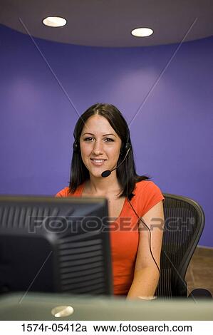 Portrait of a female customer service representative wearing a headset sitting in front of a computer monitor View Large Photo Image Stock Image - Portrait of a female customer service representative wearing a headset sitting in front of a computer monitor. Fotosearch