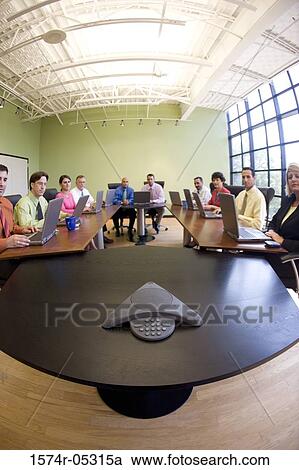 Stock Image - Portrait of a group of business executives sitting in a conference room. Fotosearch
