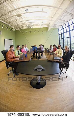 Stock Image - Portrait of a group of business executives sitting in a conference room. Fotosearch