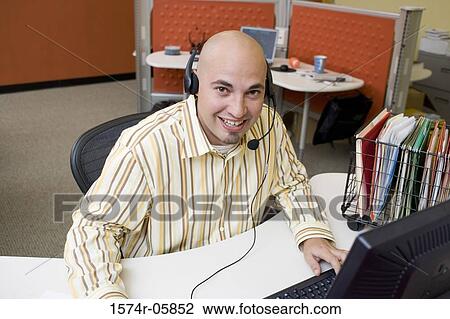 Stock Image - Portrait of a male customer service representative wearing a headset. Fotosearch