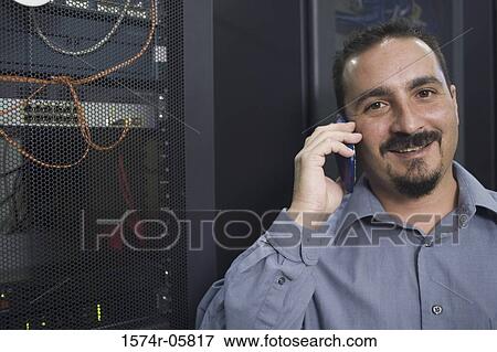 Stock Photo - Portrait of a male technician talking on a mobile phone. Fotosearch