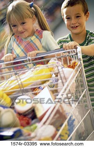 Stock Photography - Girl and a boy playing with a shopping cart in a supermarket. Fotosearch