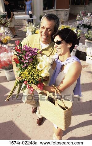 Stock Image - High angle view of a mature couple holding a bouquet of flowers. Fotosearch