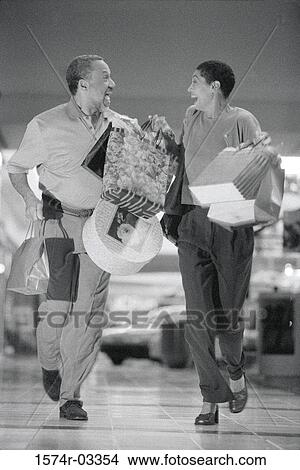 Mature couple carrying shopping bags View Large Photo Image Picture - Mature couple carrying shopping bags. Fotosearch