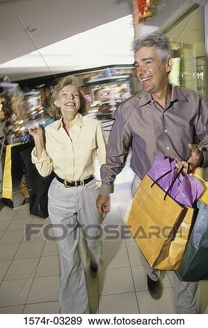 Mature couple carrying shopping bags View Large Photo Image Stock Photo - Mature couple carrying shopping bags. Fotosearch