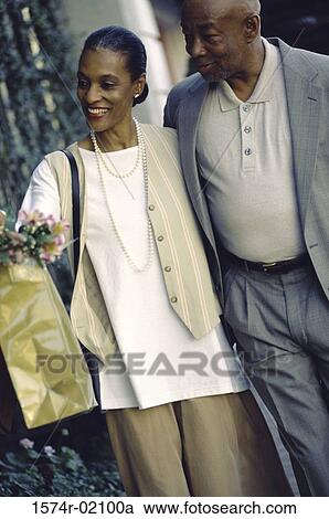 Mature couple walking with shopping bags View Large Photo Image Stock Image - Mature couple walking with shopping bags. Fotosearch