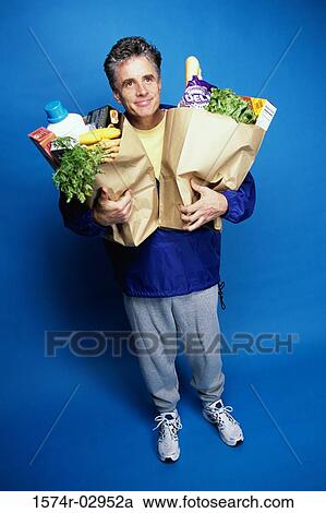 Mature man carrying two grocery bags View Large Photo Image Stock Image - Mature man carrying two grocery bags. Fotosearch