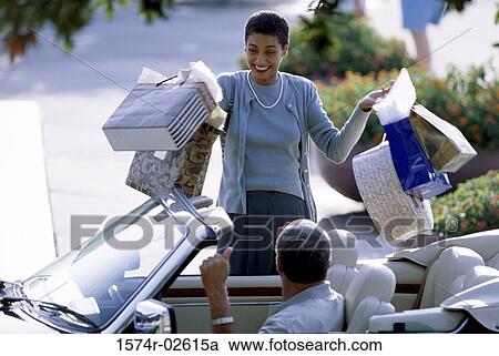 Stock Image - Mature woman carrying shopping bags. Fotosearch