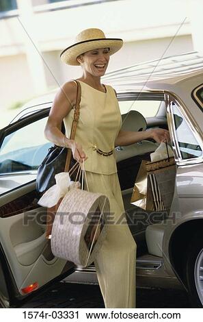 Mature woman exiting a car with shopping bags View Large Photo Image Stock Image - Mature woman exiting a car with shopping bags. Fotosearch