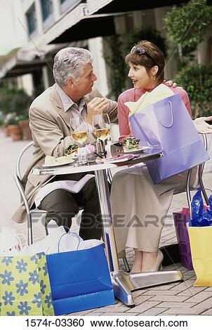 Stock Image - Mid adult couple sitting at a table. Fotosearch