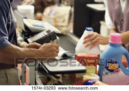 Mid section view of a man and a woman at a checkout counter in a supermarket View Large Photo Image Stock Image - Mid section view of a man and a woman at a checkout counter in a supermarket. Fotosearch