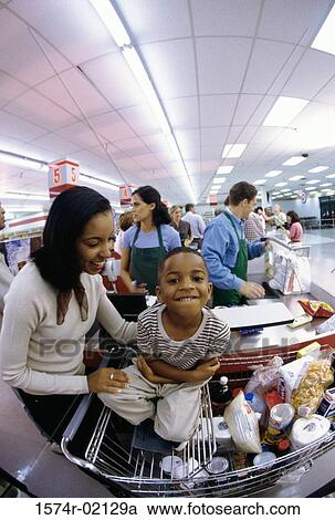 Stock Image - Mother and her son at a checkout counter in a supermarket. Fotosearch