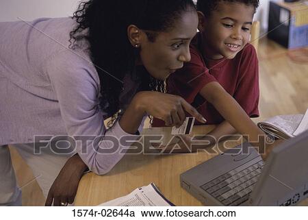 Stock Image - Mother and her son in front of a laptop. Fotosearch