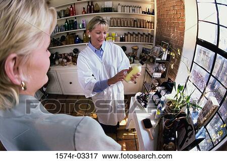 Pharmacist explaining medication to a mid adult woman View Large Photo Image Stock Photo - Pharmacist explaining medication to a mid adult woman. Fotosearch