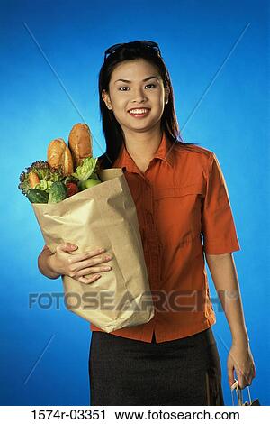 Portrait of a young woman carrying a grocery bag View Large Photo Image Stock Image - Portrait of a young woman carrying a grocery bag. Fotosearch