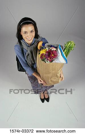 Portrait of a young woman carrying a grocery bag View Large Photo Image Stock Image - Portrait of a young woman carrying a grocery bag. Fotosearch