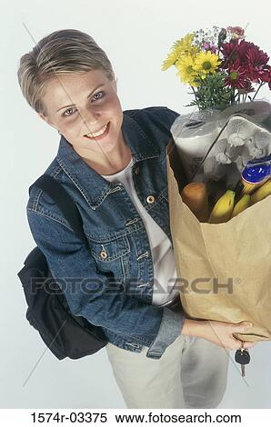 Stock Photography - Portrait of a young woman carrying a grocery bag. Fotosearch