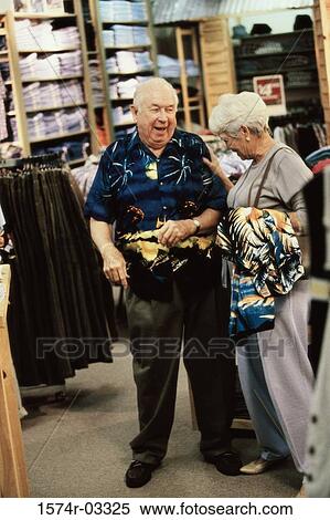 Stock Photography - Senior man trying on a shirt in a clothing store. Fotosearch