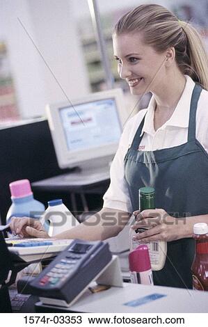 Side profile of a female sales clerk working on a cash register at a supermarket checkout counter View Large Photo Image Stock Image - Side profile of a female sales clerk working on a cash register at a supermarket checkout counter. Fotosearch