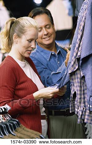Side profile of a mid adult couple shopping in a clothing store View Large Photo Image Stock Image - Side profile of a mid adult couple shopping in a clothing store. Fotosearch