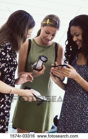 Three young women looking at shoes in a store View Large Photo Image Stock Photograph - Three young women looking at shoes in a store. Fotosearch