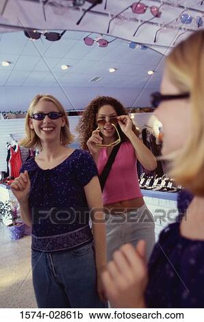 Three young women shopping for sunglasses View Large Photo Image Stock Image - Three young women shopping for sunglasses. Fotosearch