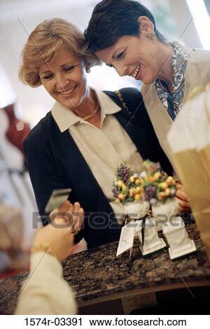 Two mature women at a store counter View Large Photo Image Stock Image - Two mature women at a store counter. Fotosearch