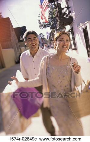Young couple walking with shopping bags View Large Photo Image Stock Image - Young couple walking with shopping bags. Fotosearch