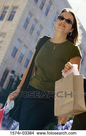 Young woman carrying shopping bags View Large Photo Image Picture - Young woman carrying shopping bags. Fotosearch