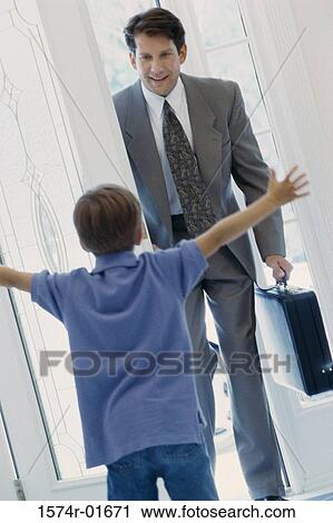 Boy greeting his father at the door View Large Photo Image Stock Image - Boy greeting his father at the door. Fotosearch