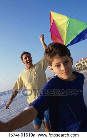 Close-up of a boy flying a kite with his father on the beach View Large Photo Image Stock Image - Close-up of a boy flying a kite with his father on the beach. Fotosearch