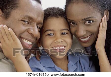 Stock Image - Close-up of a boy holding his parents faces. Fotosearch