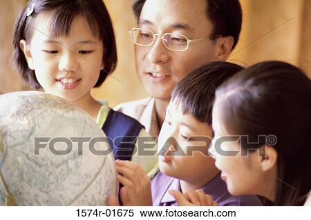 Close-up of a couple looking at a globe with their son and daughter View Large Photo Image Stock Photography - Close-up of a couple looking at a globe with their son and daughter. Fotosearch