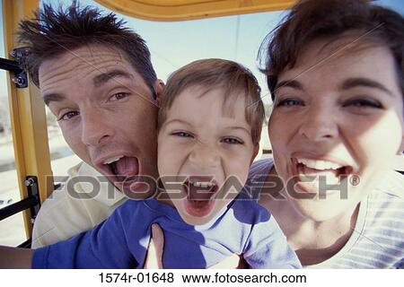 Stock Photo - Close-up of a couple on an amusement park ride with their son. Fotosearch