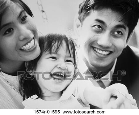 Stock Photography - Close-up of a couple with their daughter. Fotosearch