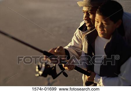Close-up of a father and son fishing together View Large Photo Image Stock Photo - Close-up of a father and son fishing together. Fotosearch