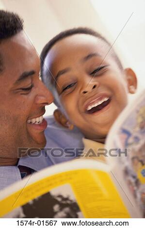 Close-up of a father reading to his son View Large Photo Image Stock Photo - Close-up of a father reading to his son. Fotosearch