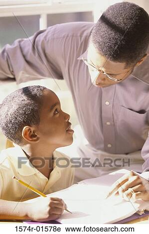 Stock Image - Close-up of a father tutoring his son. Fotosearch
