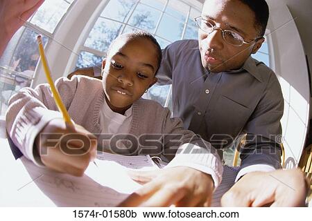 Stock Image - Close-up of a father tutoring his daughter. Fotosearch