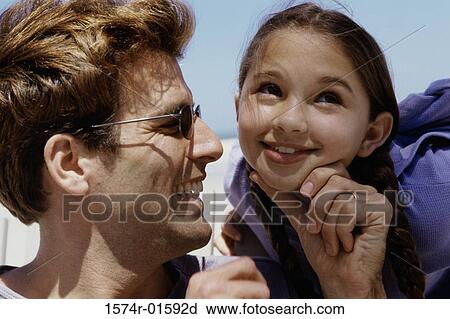 Close-up of a man holding his daughter's chin View Large Photo Image Stock Image - Close-up of a man holding his daughter's chin. Fotosearch