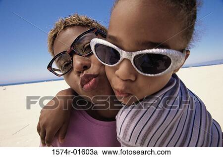 Stock Image - Close-up of a mother and daughter puckering their lips. Fotosearch