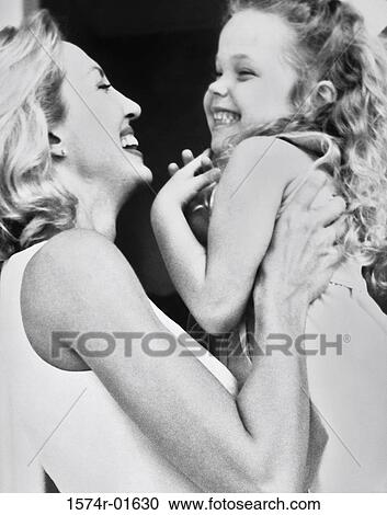 Stock Image - Close-up of a woman lifting up her daughter. Fotosearch