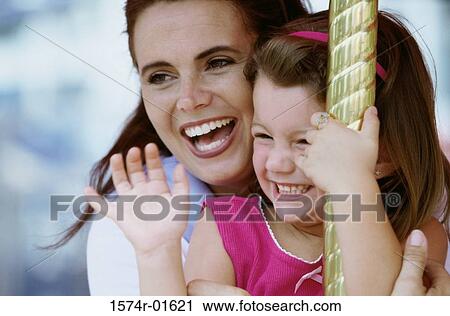 Close-up of a woman on a carousel with her daughter View Large Photo Image Stock Image - Close-up of a woman on a carousel with her daughter. Fotosearch