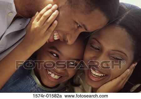 Stock Image - Close-up of parents and their daughter smiling. Fotosearch