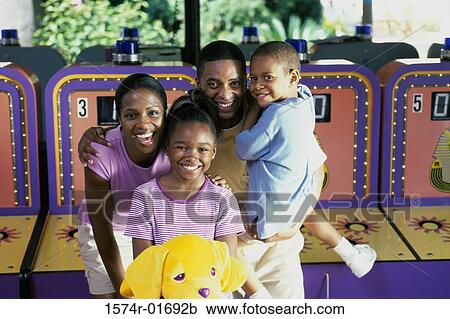 Couple in an amusement park with their son and daughter View Large Photo Image Stock Image - Couple in an amusement park with their son and daughter. Fotosearch