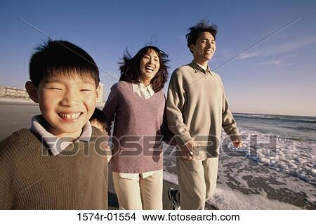 Couple walking with their son at the beach View Large Photo Image Picture - Couple walking with their son at the beach. Fotosearch